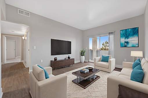 A living room with a large couch, a coffee table, and a television.