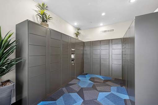 A hallway with a blue tiled floor and grey walls.