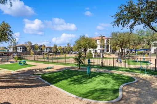 a dog park with a green grassy area and a playground