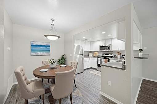 A modern kitchen with a dining table and chairs.