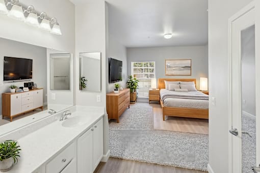 A bedroom with a bed, dresser, and mirror.