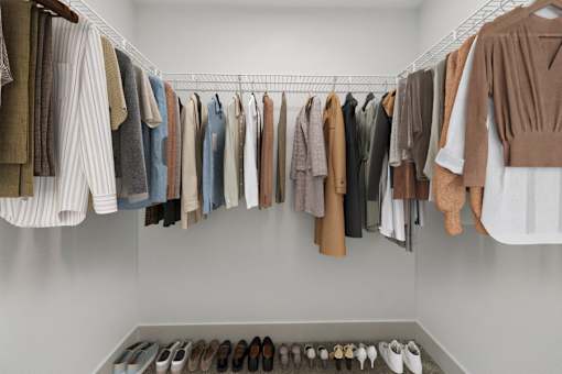a rack of clothes and shoes in a closet