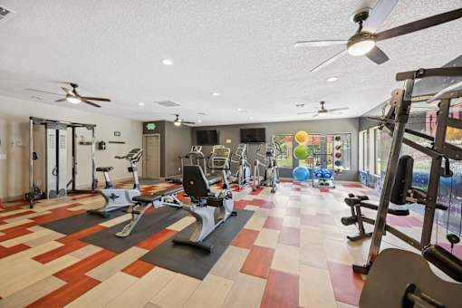 A gym with a variety of exercise equipment and a checkerboard floor.