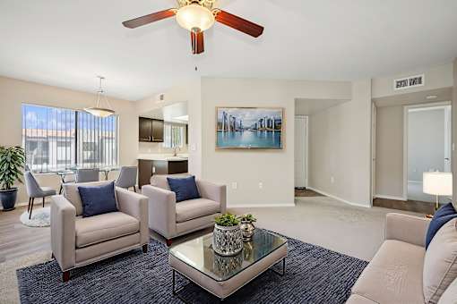 A living room with a ceiling fan, two couches, and a coffee table.