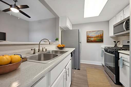 A kitchen with a bowl of oranges on the counter.