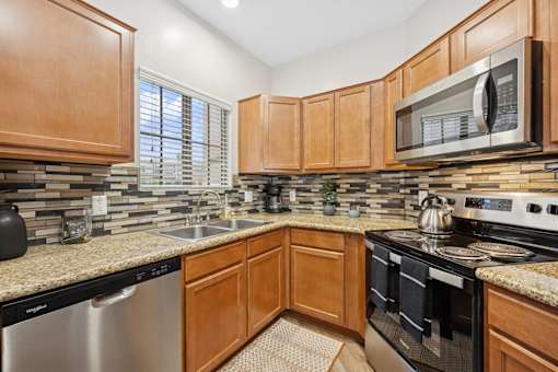 A kitchen with wooden cabinets and a granite countertop.