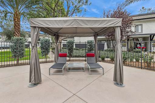 A patio with a canopy and two chairs.