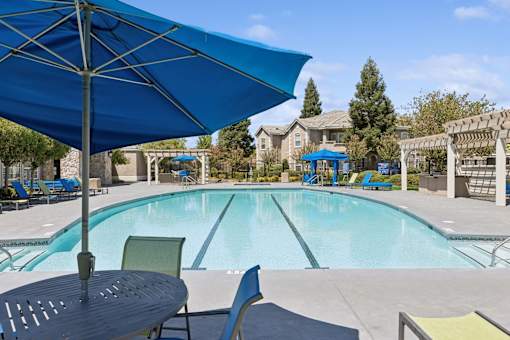 our apartments have a swimming pool with chairs and umbrellas