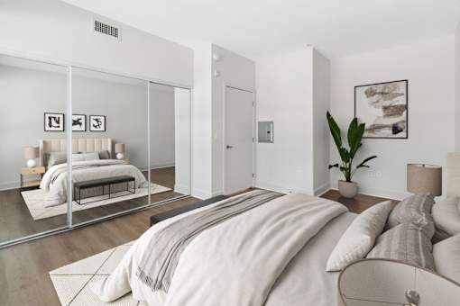 a bedroom with a large bed and a mirror