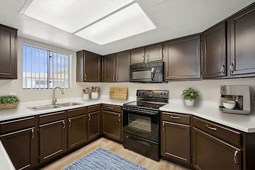 A kitchen with brown cabinets and a black stove top oven.