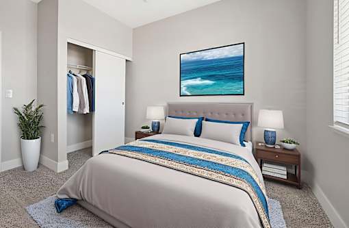 A bedroom with a large bed and a painting of a beach scene on the wall.