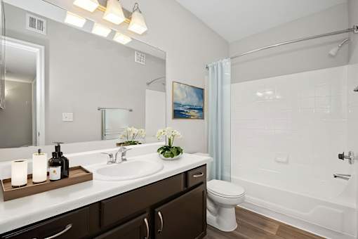 A bathroom with a white sink and a white toilet.