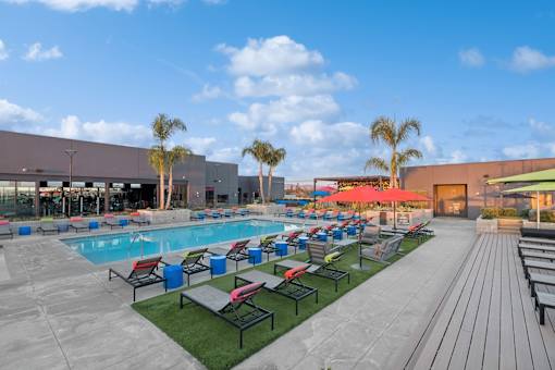 A large outdoor swimming pool area with loungers and umbrellas.