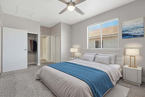 A bedroom with a large bed and a ceiling fan.
