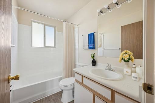 A white bathroom with a toilet, sink, and bathtub.