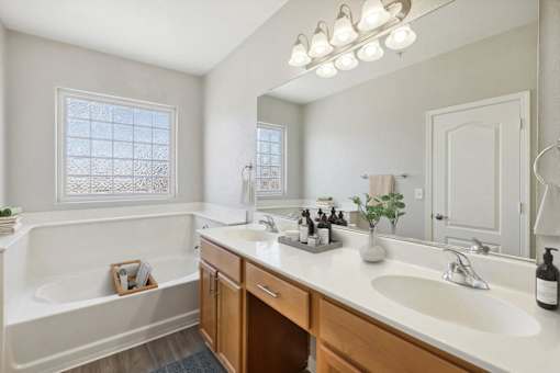 a bathroom with a sink and a tub and a mirror