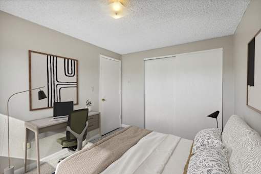 a bedroom with a bed and a desk with a computer
