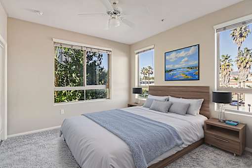 A bedroom with a large bed and a ceiling fan.