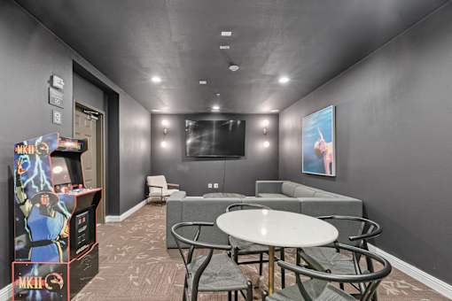 a gaming room with a table and chairs and a television