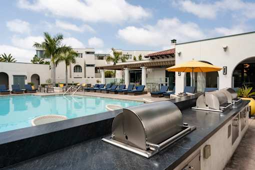 A pool with a slide and a building in the background.