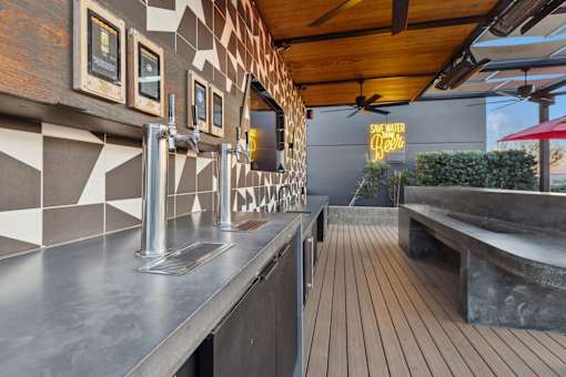 A modern bar with a wooden floor and a metal counter.