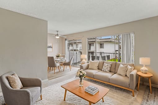 A living room with a grey couch, a wooden coffee table, and a grey armchair.