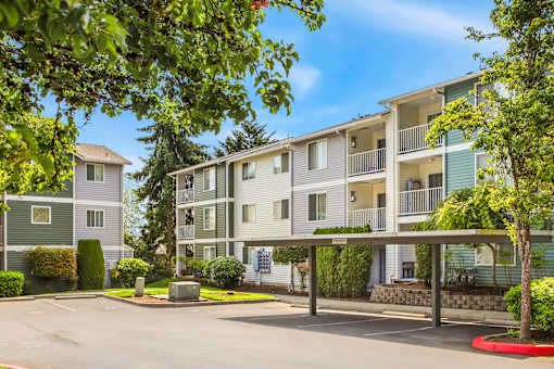 Apartment complex with green trees in front.