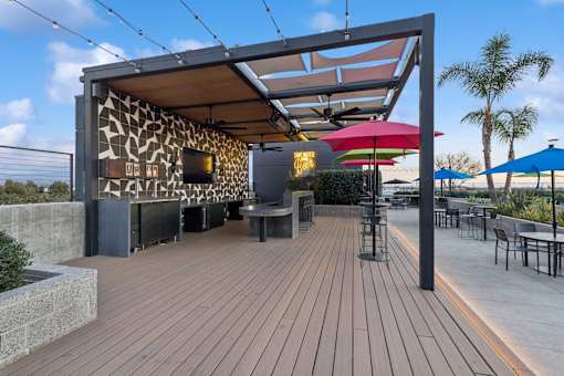 A wooden deck with a shaded area and tables.