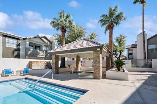 A pool with a slide and a gazebo in the middle of it.