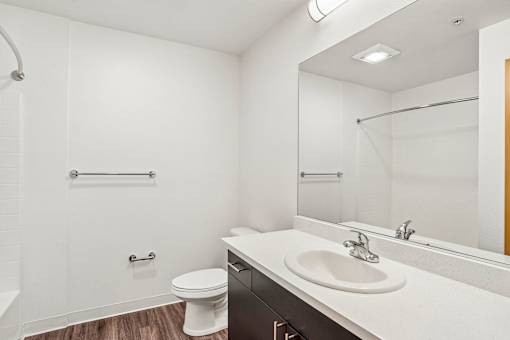A white bathroom with a toilet, sink, and shower.