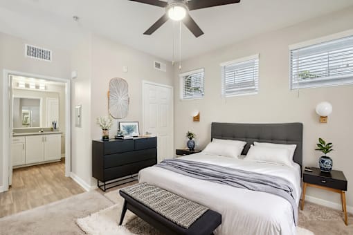 A bedroom with a large bed and a ceiling fan.