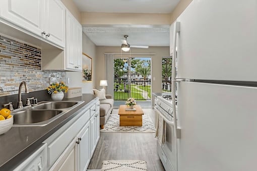 A kitchen with white cabinets and a white refrigerator.