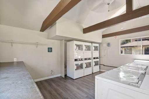 a kitchen with white appliances and a large window
