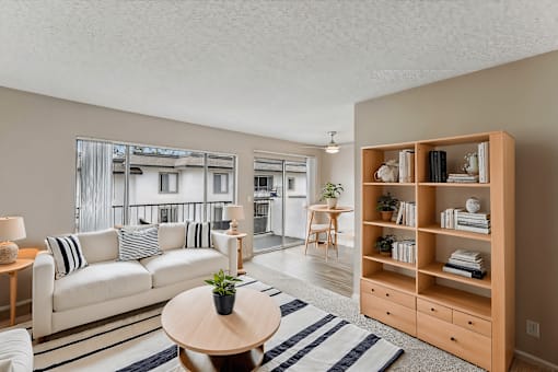 A living room with a white couch and a wooden bookshelf.