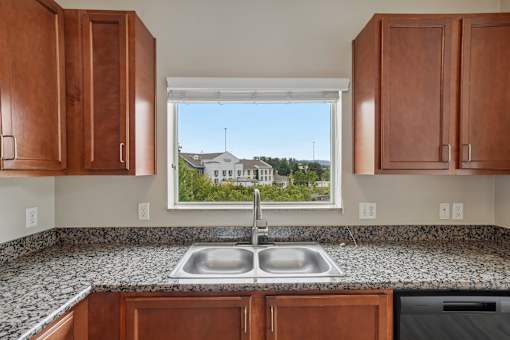 A kitchen with a double sink and wooden cabinets.