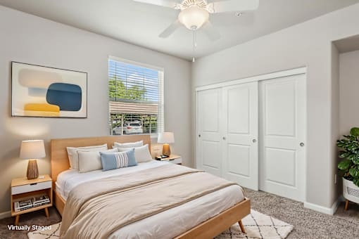 A bedroom with a large bed and a ceiling fan.