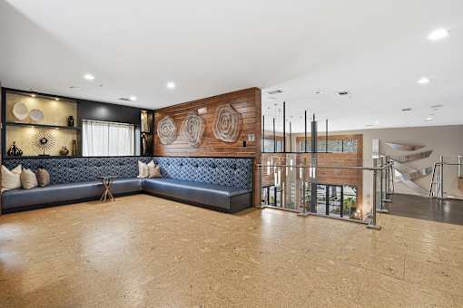 A modern living room with a blue couch and a wooden wall.