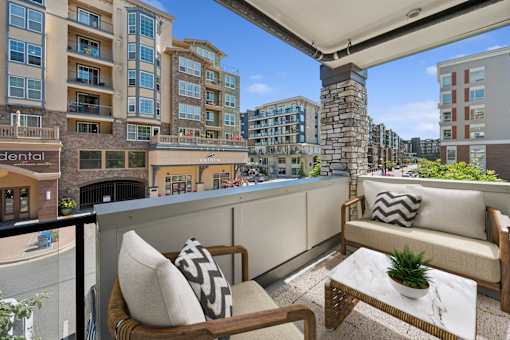 a balcony with a city view and a couch and chairs