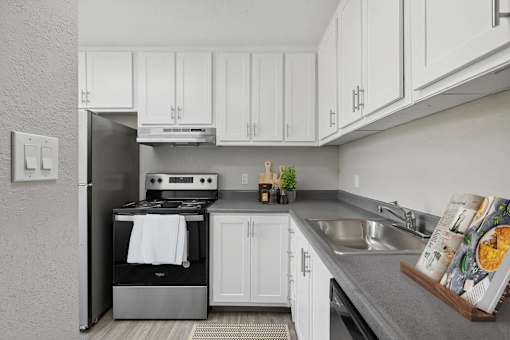 a white kitchen with stainless steel appliances and white cabinets