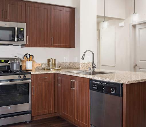 A kitchen with brown cabinets and a granite countertop.