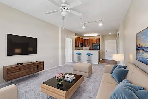 A living room with a brown coffee table and a flat screen TV mounted on the wall.