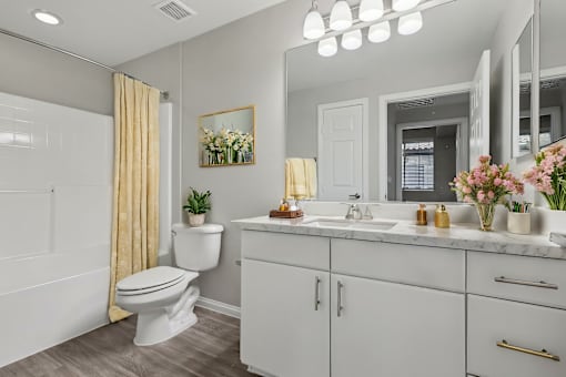 A bathroom with a white toilet, sink, and vanity.
