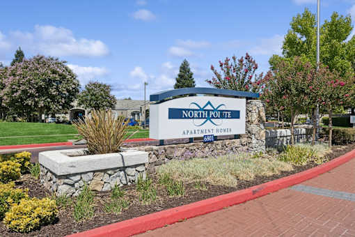 the sign in front of a brick sidewalk and grass
