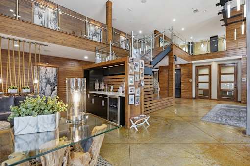 A modern interior with a wooden staircase and a glass table.