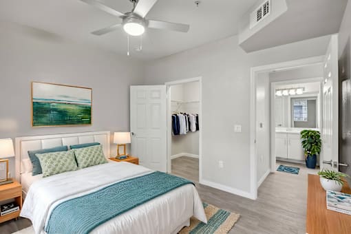 A bedroom with a large bed and a painting on the wall.