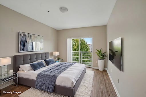 A bedroom with a large bed and a flat screen TV mounted on the wall.