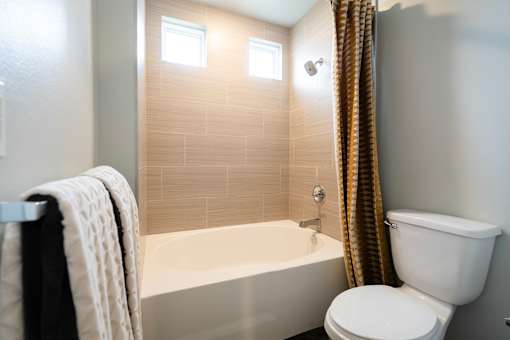 A white toilet sits next to a bathtub in a bathroom.