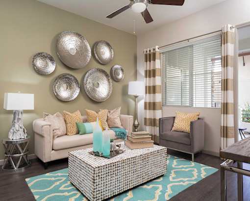 A living room with a sofa, armchair, and decorative wall pieces.