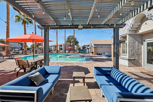 A patio with a pool and a blue couch.