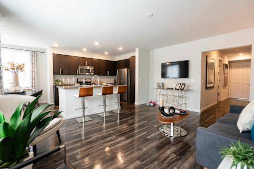 A modern kitchen with dark wood floors and white walls.